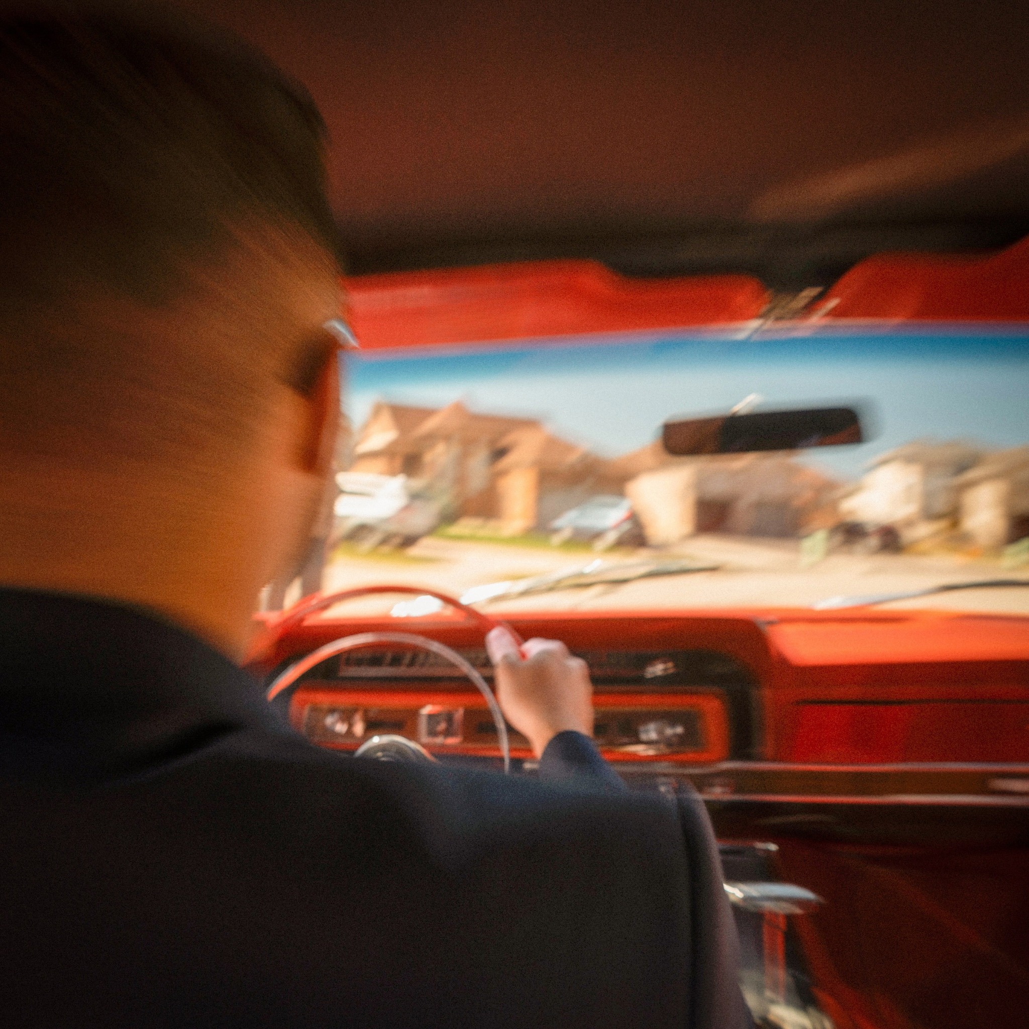 Nicholas Petrungaro driving a classic red car on the Back On Track single cover