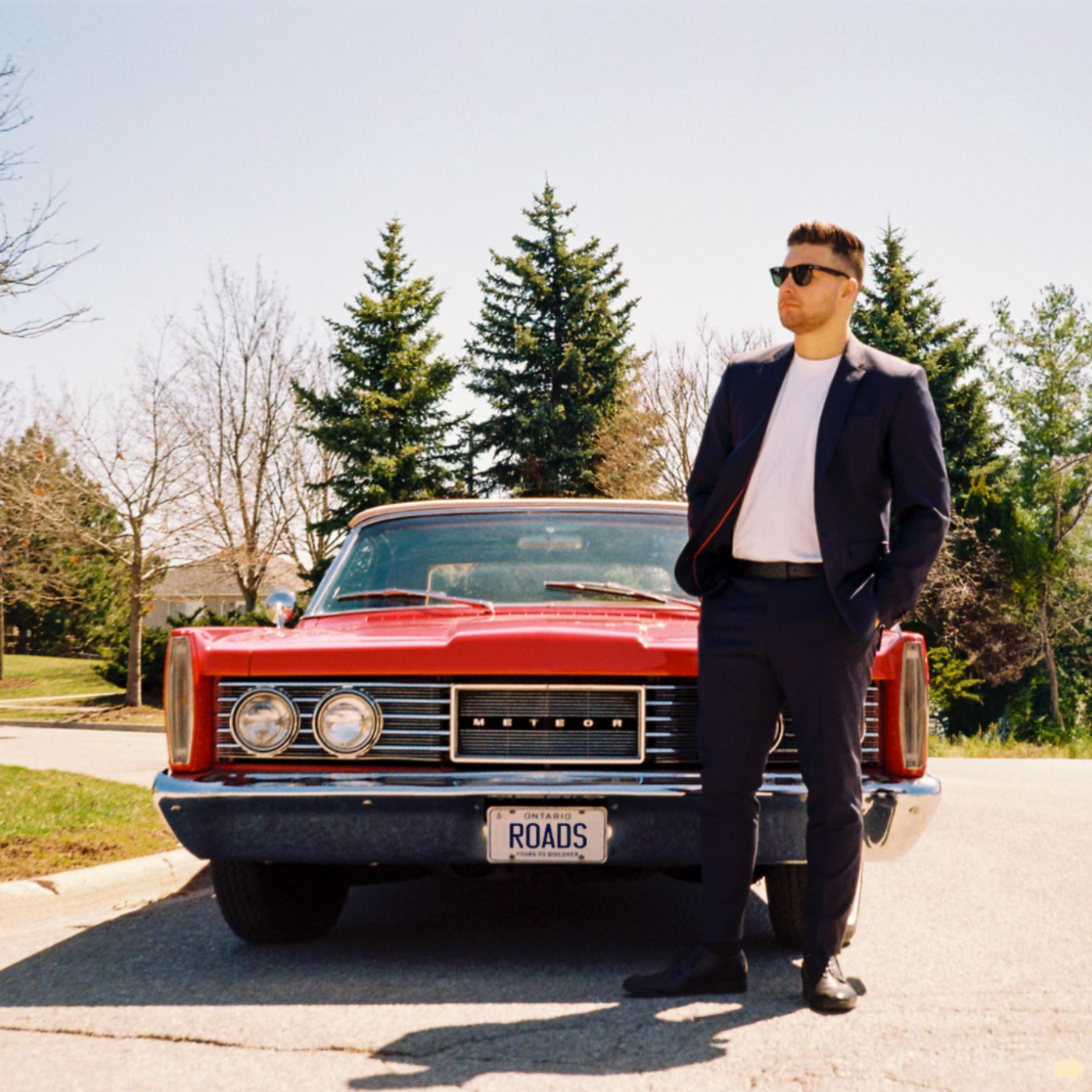 Nicholas Petrungaro beside a classic red car on the Roads single cover